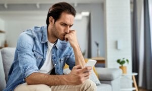 Man staring at his phone with a worried expression
